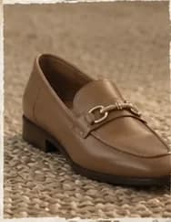 Mocassim caramelo com fivela dourada, num tapete de sisal